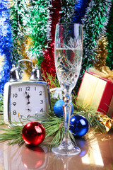 Glass of sparkling shampagne wine clock and gift box on christmas background