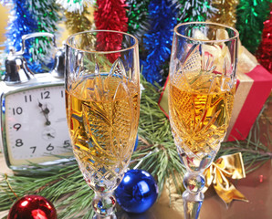 Glass of sparkling shampagne wine clock and gift box on christmas background
