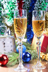 Glass of sparkling shampagne wine clock and gift box on christmas background
