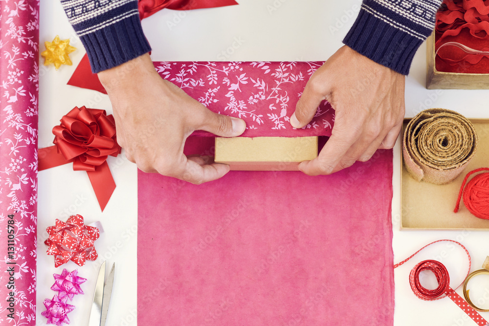 Poster young man wrapping a gift