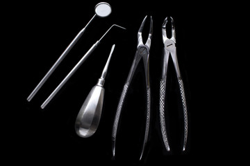 Set of metal medical equipment tools for teeth dental care isolated on black