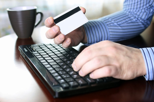 man pays for online purchases with a credit card