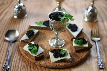 snack black caviar on a wooden background