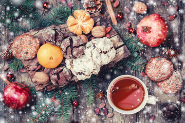 Christmas card. Cookies Chocolate, tea, pomegranate, Tangerines, Nuts, cocoa beans, Fir branches on wooden background. Xmas and Happy New Year theme. Top view, selective focus