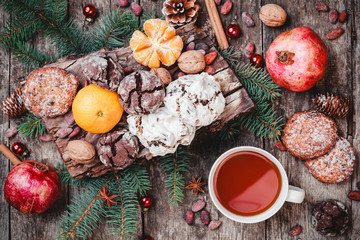 Christmas card. Cookies Chocolate, tea, pomegranate, Tangerines, Nuts, cocoa beans, Fir branches on wooden background. Xmas and Happy New Year theme. Top view, selective focus