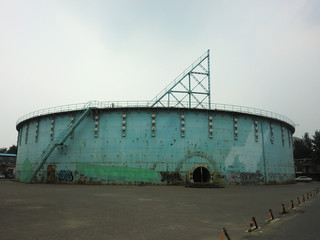 Large industrial round storage tank covered in spray paint graffiti