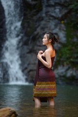 Fototapeta premium Asian woman wearing traditional thai take a baht on during sunset,vintage style,Beautiful woman take a baht,woman take a baht in river,Woman thai culture