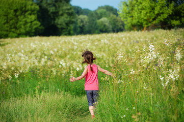Fototapeta premium Child on green spring meadow, kid running and having fun outdoors 