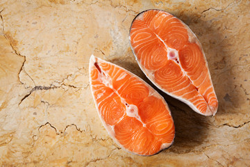 Two fresh raw salmon steaks with salt, peppers, lemon, tomatoes