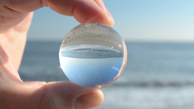 Shooting through a crystal sphere. Shooting on the sea beach.