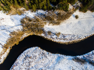 Aerial photo of curved river and snowy bank