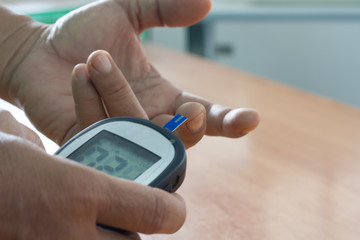 Man holding measuring blood sugar levels with him own. The concept of self-care.
