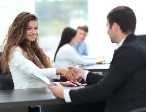 beautiful female Manager shaking hands with a client at the work