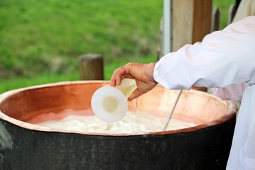 cheesemaker pour rennet into the great copper cauldron to make c