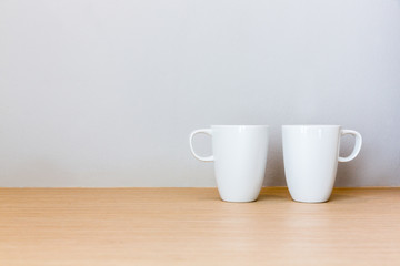 White cups on wooden bar table in bed room with blank space for text
