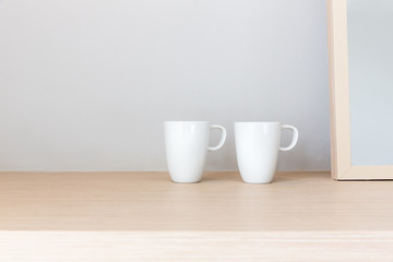 White cups on wooden bar table in bed room with blank space for text