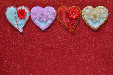Four beaded jewelry on a red glitter background