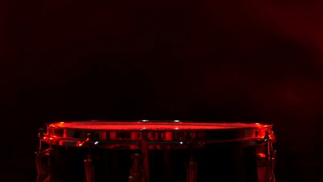 Close up of drums perfused with water for special effect, red backgrounds