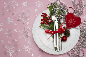 Christmas table place setting with pine branches,ribbon and bow.