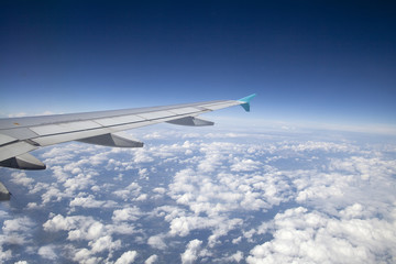 Wing of an airplane flying above the clouds