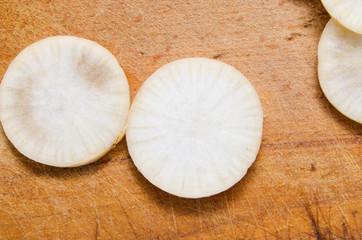 vegetable daikon sliced on a wooden cutting board close up