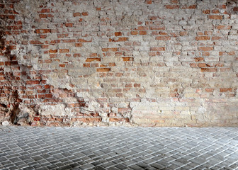Vintage background. Old crumbling wall from a clay brick, pavement of gray concrete tiles.