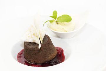 A piece of cream cake decorated with chocolate and mint