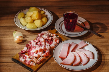 Ham, bacon, potatoes and onion on rustic background