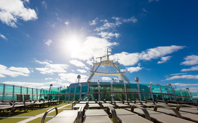 View on blue sy and sun from top deck full of sunbads on luxury
