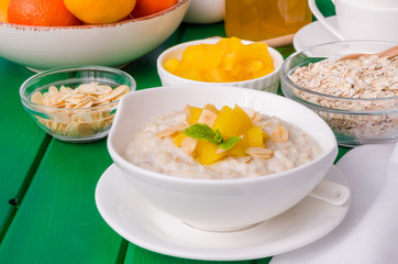 Oatmeal porridge with mango and almonds for breakfast