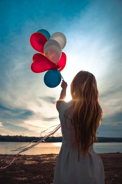 girl holding balls on the background of sunset