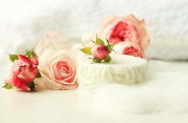 White Soap bar with cleansing foam bubbles, fresh pink garden roses. All-natural homemade botanical skincare. Warm calming tones.