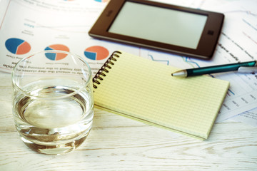 Workplace in office, glass of water and schedules