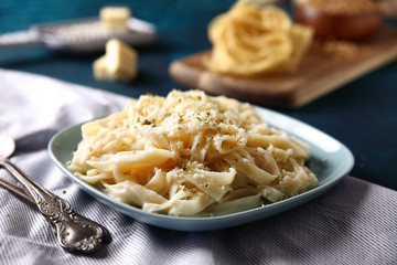 boiled Italian tagliatelle noodles on wood background