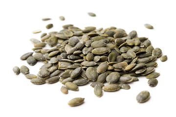 Semi di zucca decorticati e isolati su fondo bianco