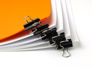 several stacks of paper held by binder clips, shallow depth of field