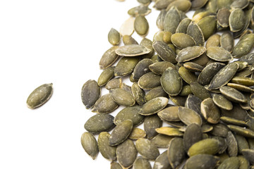 Semi di zucca decorticati e isolati su fondo bianco