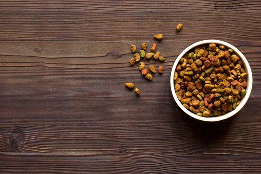 Dry Cat Food In Bowl On Wooden Background Top View