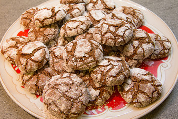 Biscotti artigianali al cacao con zucchero a velo su piatto natalizio