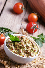 Homemade mustard with seeds in a white bowl, selective focus