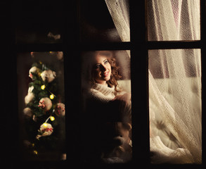 happy cheerful girl  looking through the frozen window