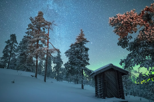 Northern lights over hut and campfire, Finland