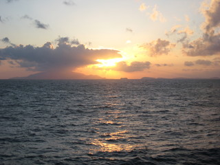 Sunset Through The Clouds On The Ocean Waves At Sea