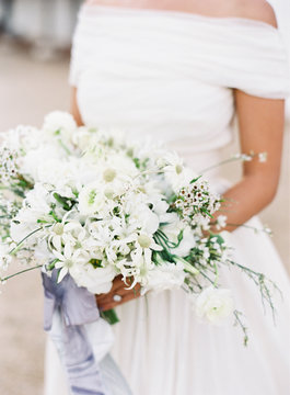 Mid section of a bride holding a flower bouquet