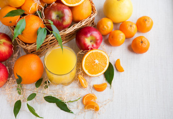 Fresh orange juice in a glass on a background of fruit baskets