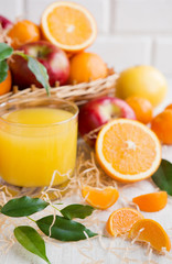 Fresh orange juice in a glass on a background of fruit baskets