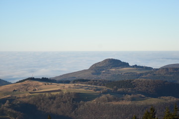 Hügel in der Sonne, Wolken im Tal