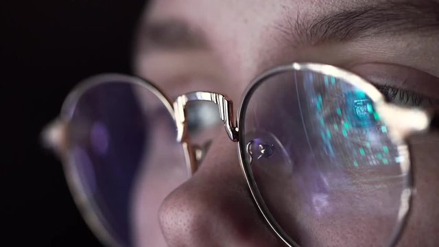 The Machine Code is Reflected in the Hacker's Glasses. Close-up Shot