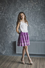Naklejka premium A life-size portrait of a girl in a skirt and with long hair on