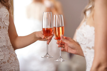 Toast at celebration, girls holding glasses with pink champagne. Birthday or wedding party concept. Two lesbians with champagne glasses on hen party 
